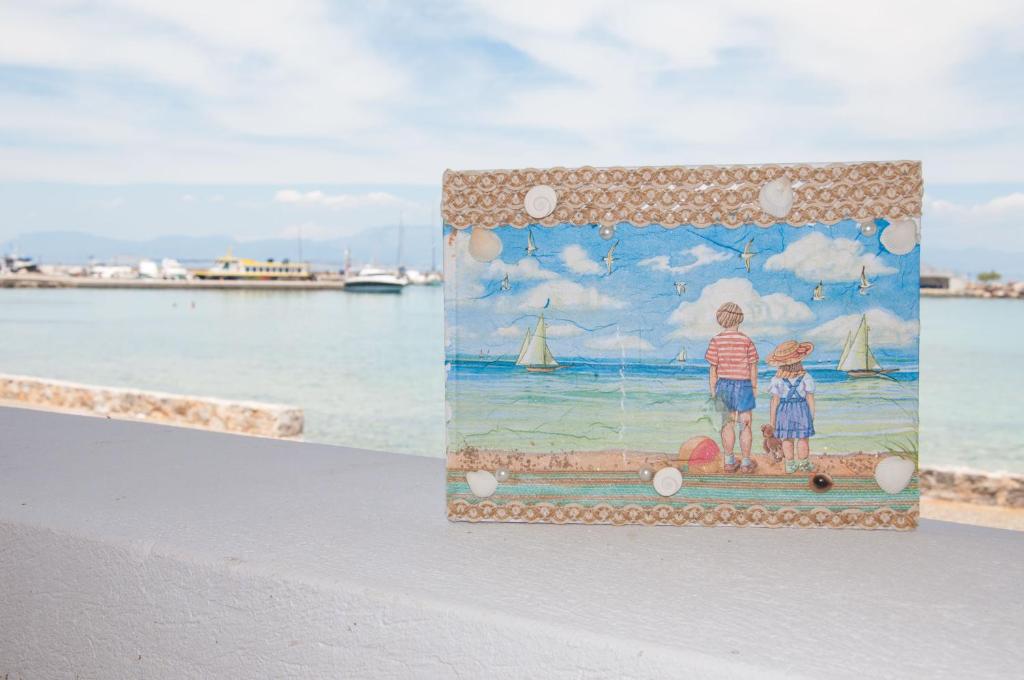 a painting of two children standing on the beach at Nautilus Nontas Hotel in Megalochori