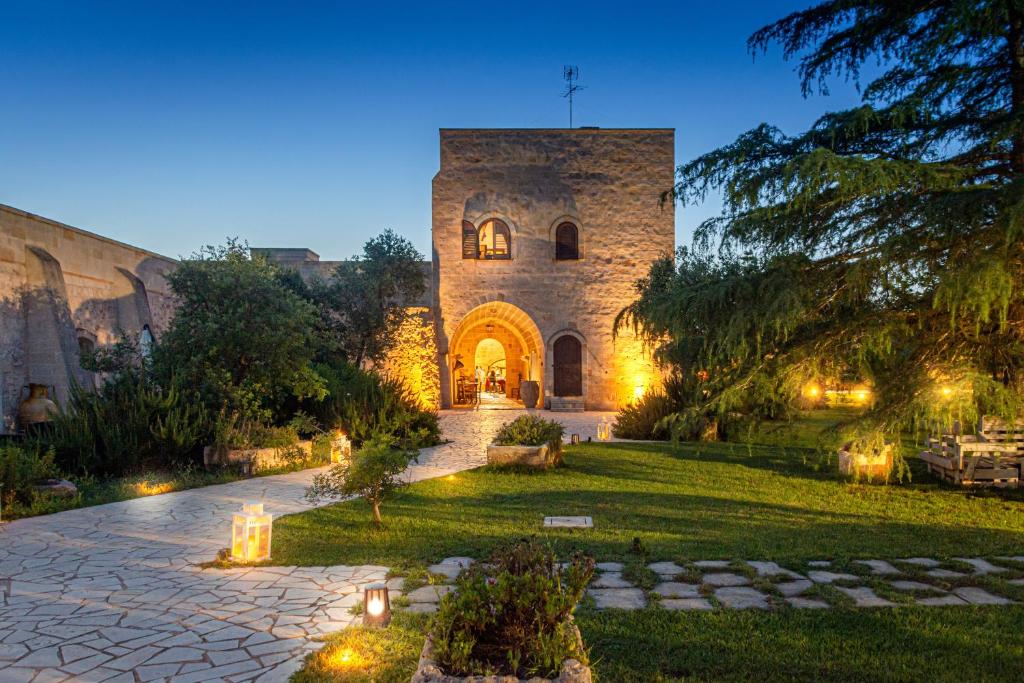 un gran edificio de piedra con luces en el patio en Masseria Nuova, en Francavilla Fontana