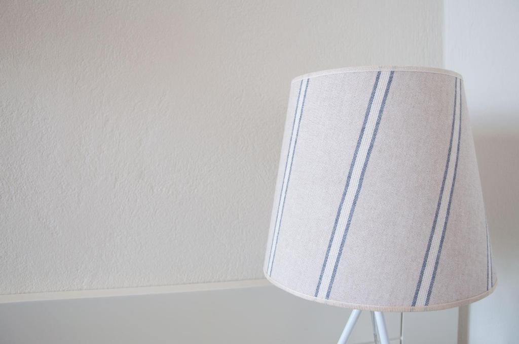 a white lampshade sitting next to a wall at Nautilus Nontas Hotel in Megalochori