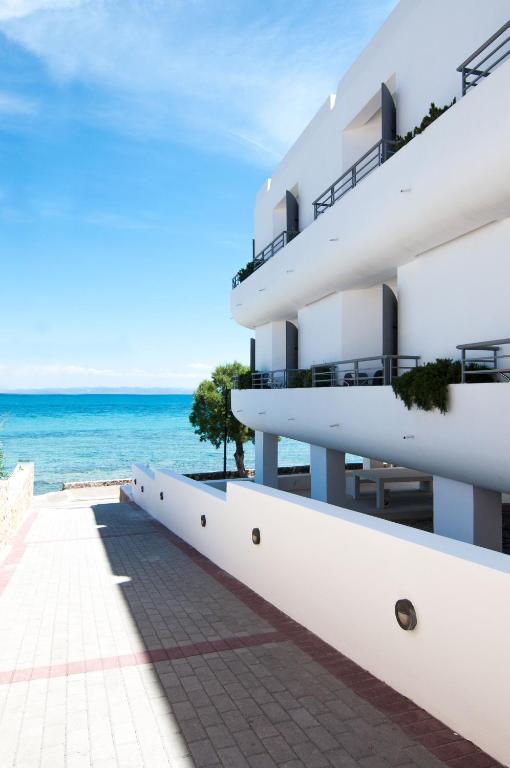 a white building with the ocean in the background at Nautilus Nontas Hotel in Megalochori