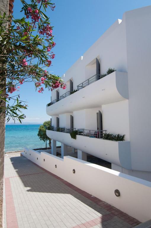 a white building with the ocean in the background at Nautilus Nontas Hotel in Megalochori