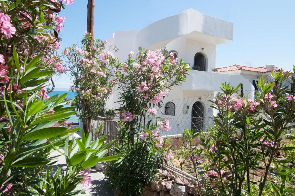 a white house with pink flowers in front of it at Nautilus Nontas Hotel in Megalochori