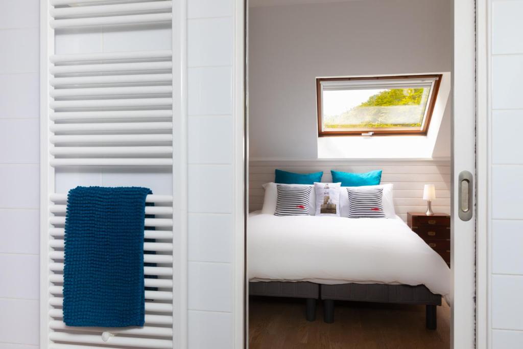 a bedroom with a bed with blue and white pillows at Les Vestiges du jour in Clohars-Fouesnant