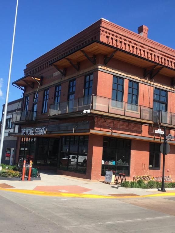 een groot bakstenen gebouw op de hoek van een straat bij The Hotel Sturgis in Sturgis