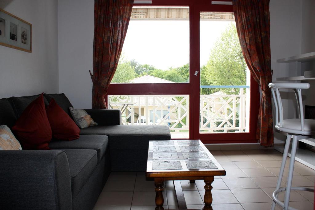 - un salon avec un canapé, une table et une fenêtre dans l'établissement T2 duplex au 2éme étage sur le port ostreicole Andernos ,Bassin d'Arcachon, à Andernos-les-Bains