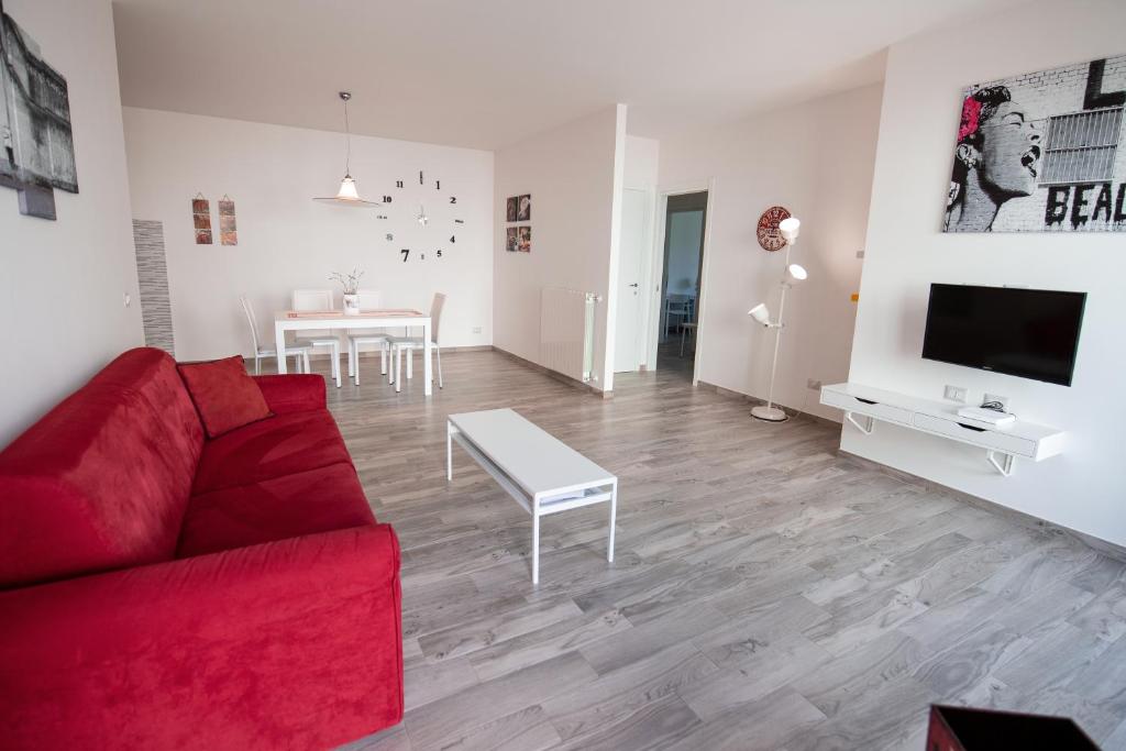 ein Wohnzimmer mit einem roten Sofa und einem Tisch in der Unterkunft Apartment Bolsena in Bolsena
