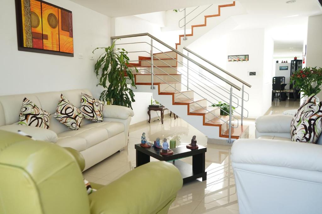 a living room with couches and a staircase at Posada Ventura in Duitama