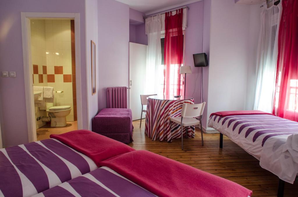 een hotelkamer met 2 bedden en een badkamer bij Pensión Blanca B&B in León