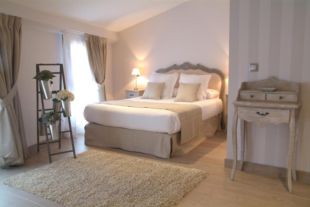 Un dormitorio con una cama grande y una mesa con una escalera. en Le Petit Boutique Hotel en Santander