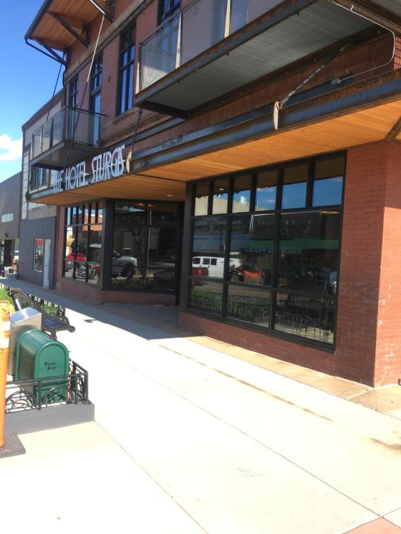 a store front of a brick building with windows at The Hotel Sturgis in Sturgis