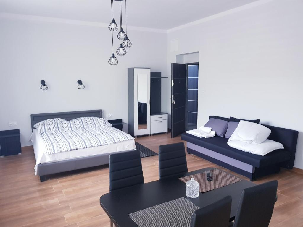 salon z łóżkiem i stołem w obiekcie Apartamenty Polna w Ostrowcu Świętokrzyskim