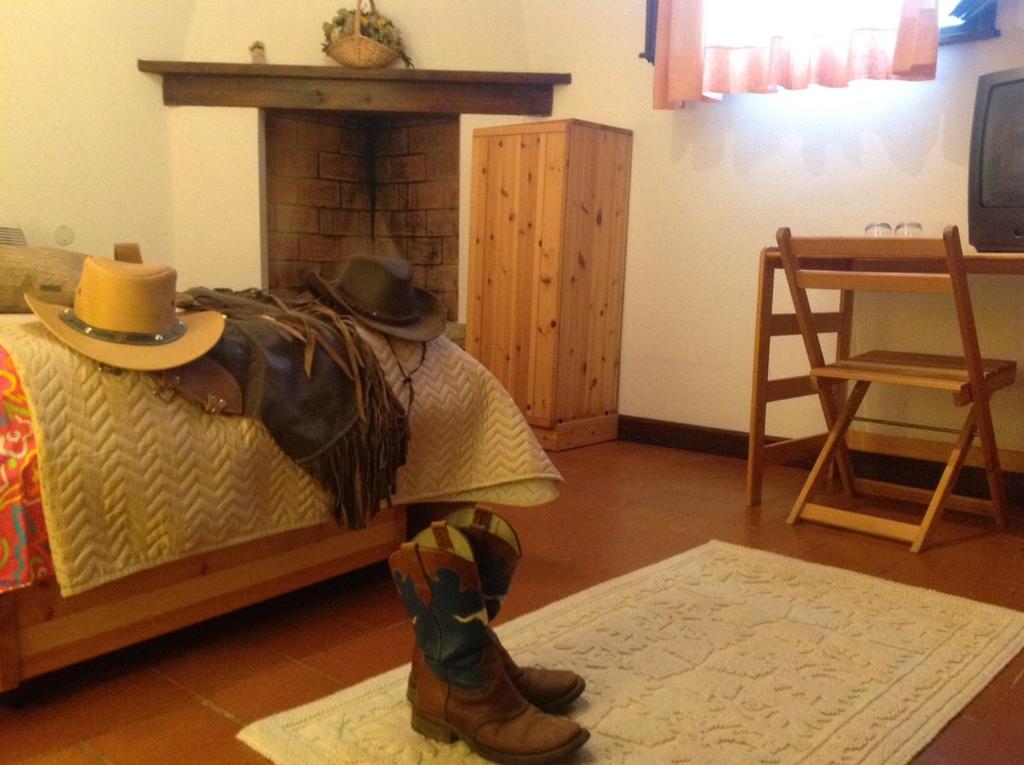 a man wearing a cowboy hat sitting on a bed at Agriturismo Ai Gradoni in Teolo