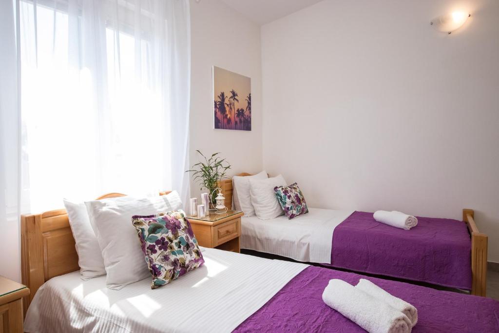 2 camas en una habitación de color púrpura y blanco en Villa Kovacevic, en Bar