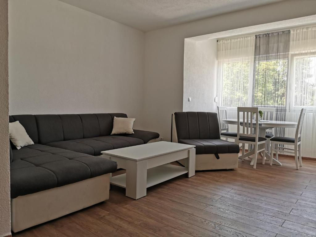 a living room with a couch and a table and chairs at Apartman MMS in Teslić