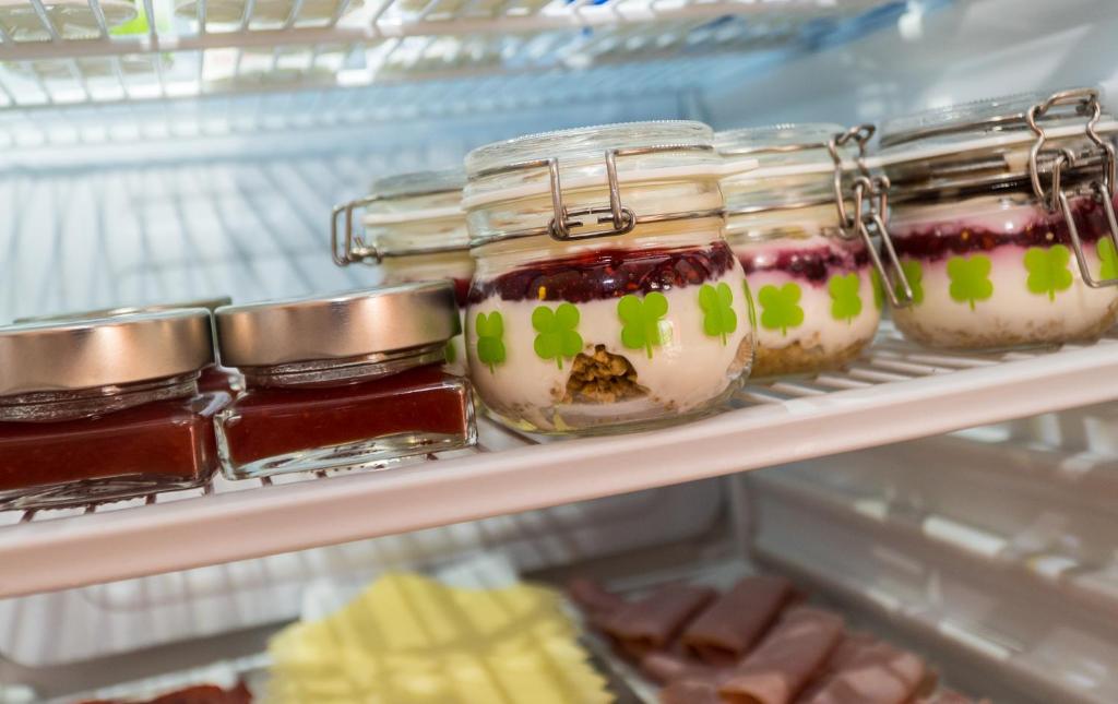 a refrigerator filled with jars of jam and desserts at Hostal Casa Mercedes in Nerja