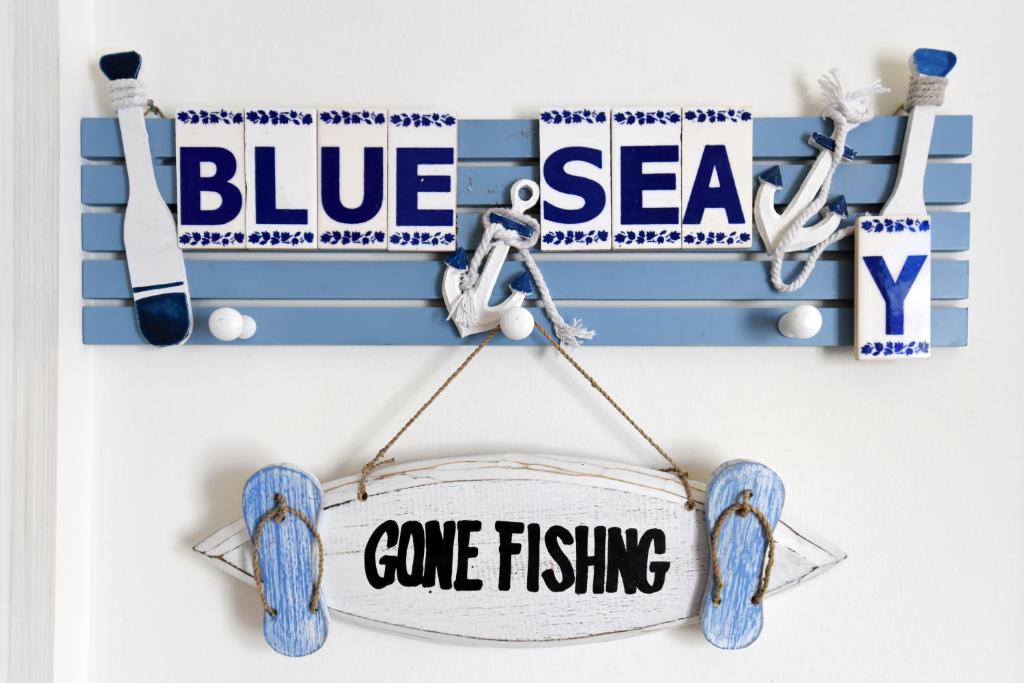 een bord dat zegt blauw en een wild vissen bij Blue Sea Y in Kavala
