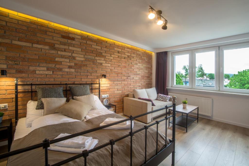 um quarto com uma parede de tijolos e uma cama em Sea You Apartments- Okrzei em Sopot