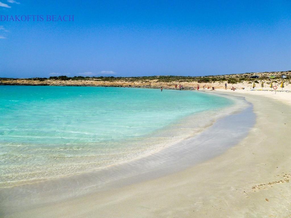 a beach with blue water and people on it at Amaryllis Hotel in Karpathos
