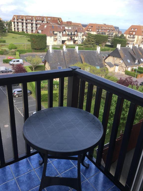- une table sur un balcon avec vue sur la rue dans l'établissement Appartement vue mer, à Villers-sur-Mer