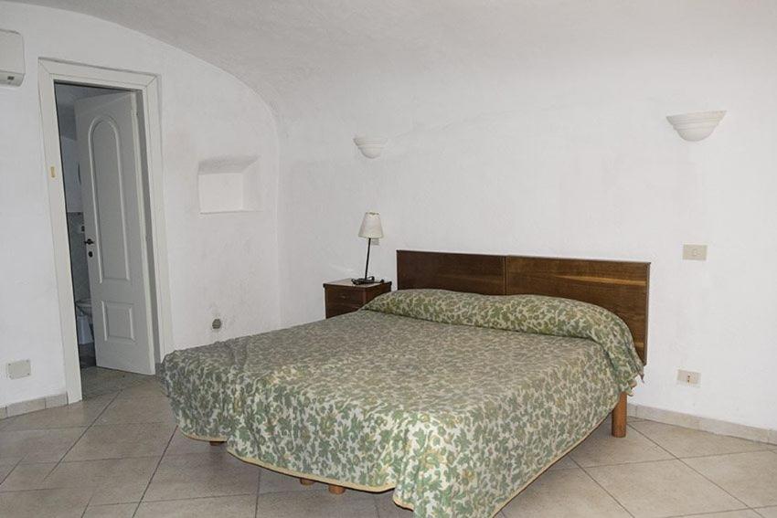 a bedroom with a bed with a green bedspread at Renato Canalone in Ponza