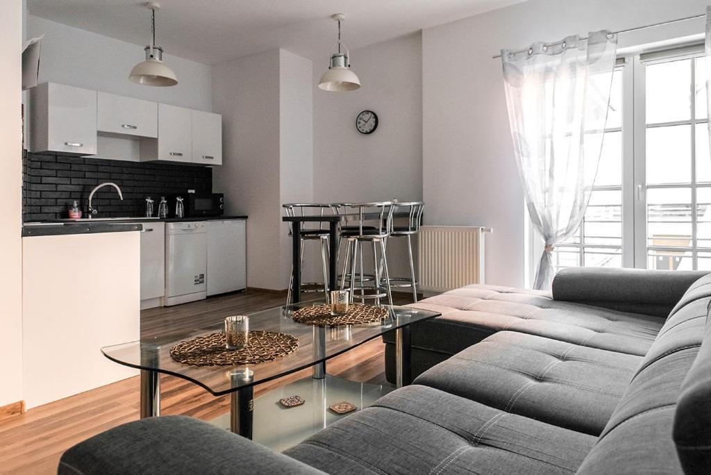 een woonkamer met een bank en een tafel bij Apartament na Wyspie Piasek in Kłodzko