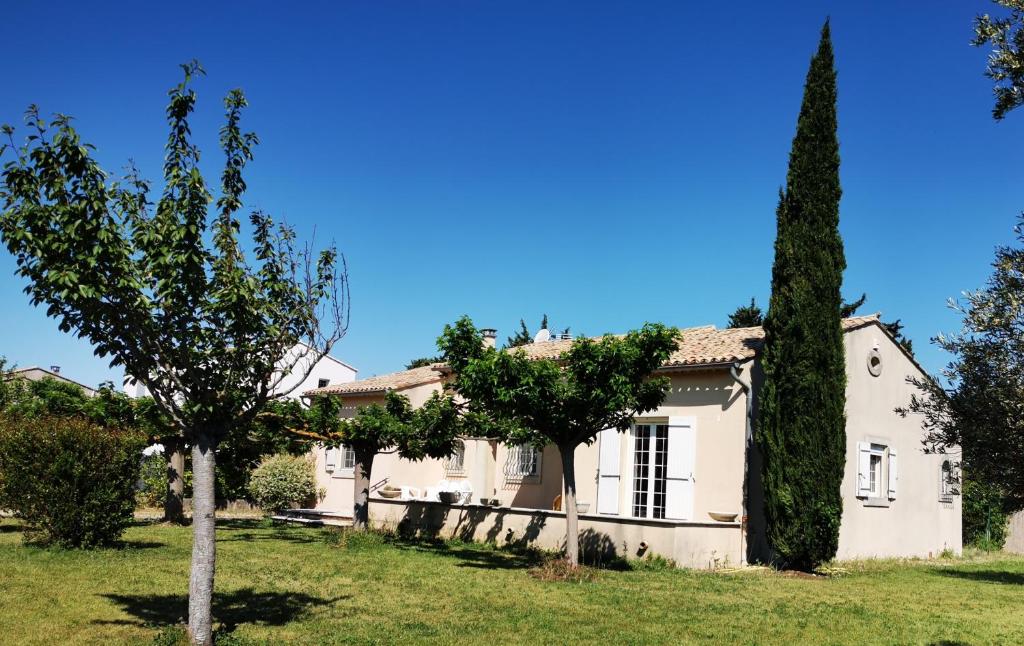 una casa blanca con un árbol en el patio en Aux portes du Luberon, en Cheval Blanc