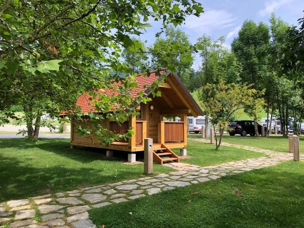 eine kleine Holzhütte in einem Park mit Bäumen in der Unterkunft Camp Podgrad Vransko in Vransko