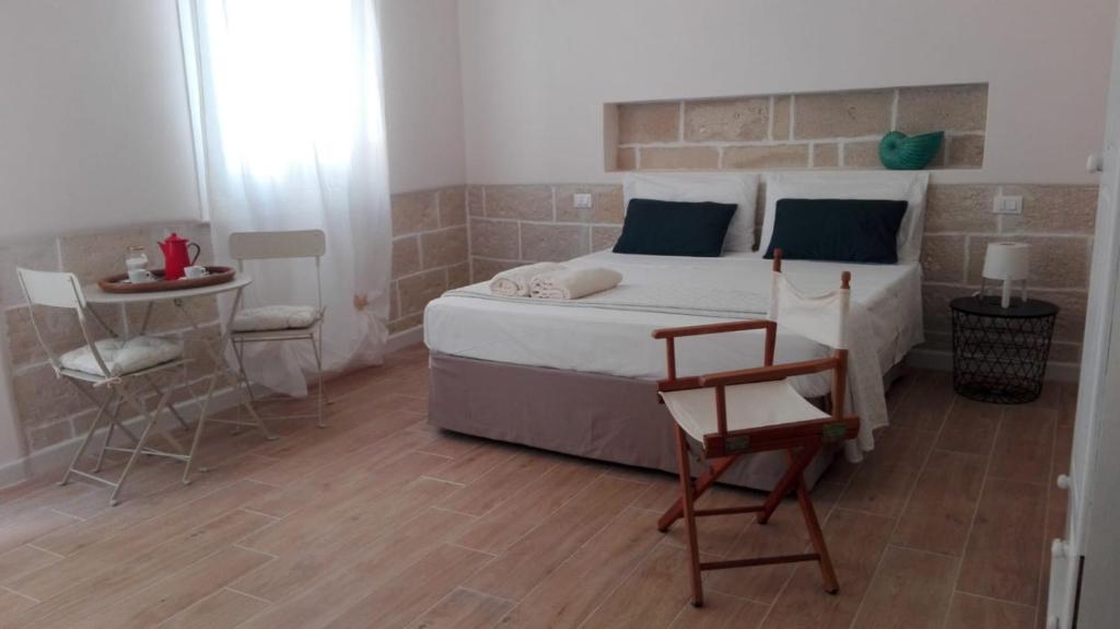 una camera con letto, sedia e tavolo di Il Viaggiatore a Marettimo