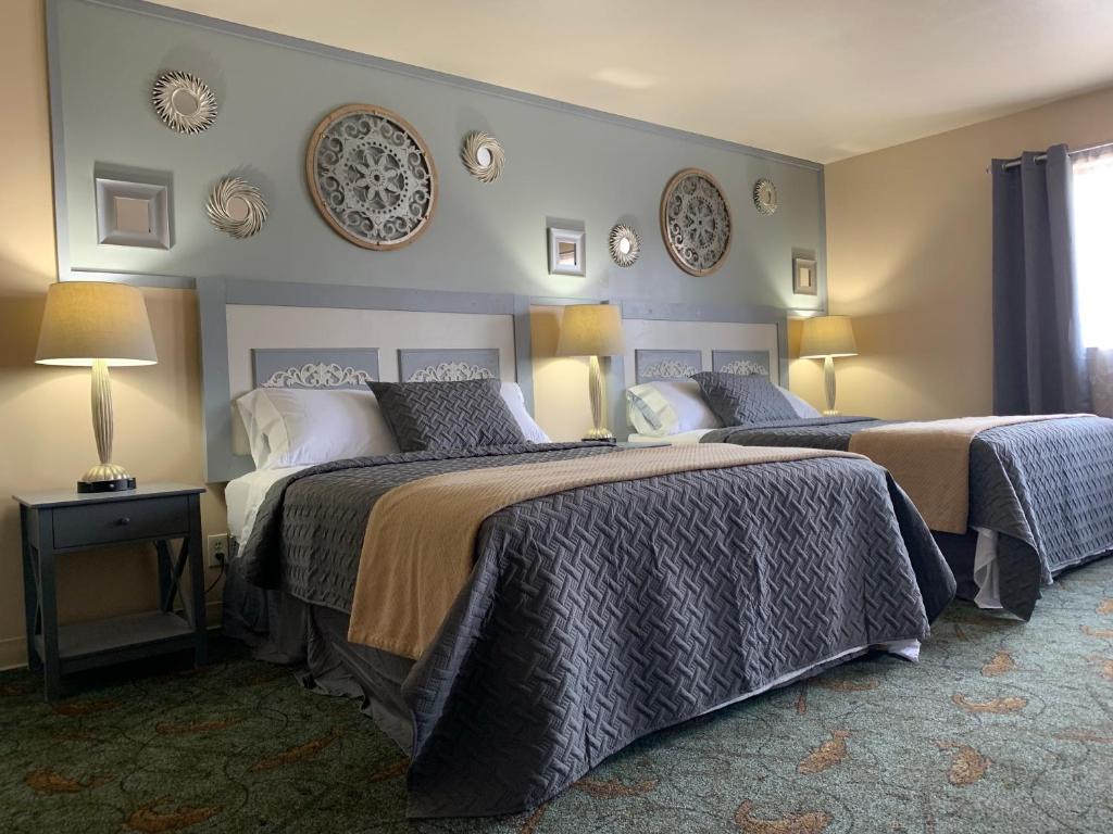 a bedroom with two beds and plates on the wall at Alaska Angler's Inn in Soldotna