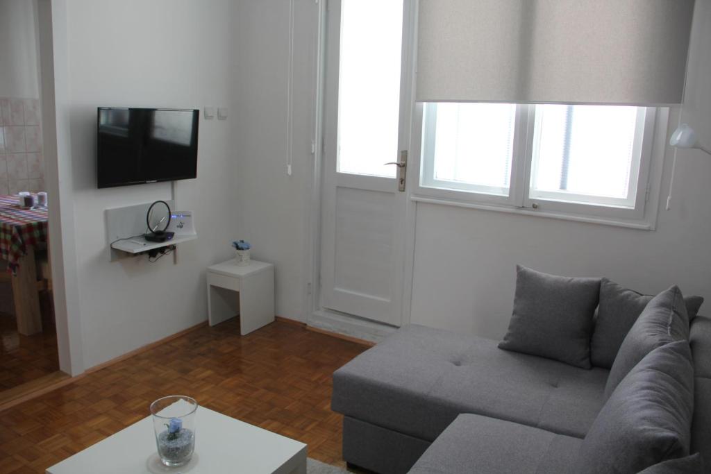 a living room with a couch and a tv at Apartman KEJ in Pirot
