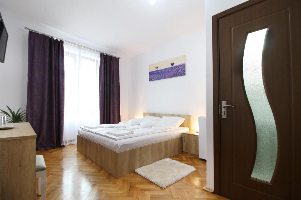 una piccola camera con un letto e una porta di Anne's House a Sibiu