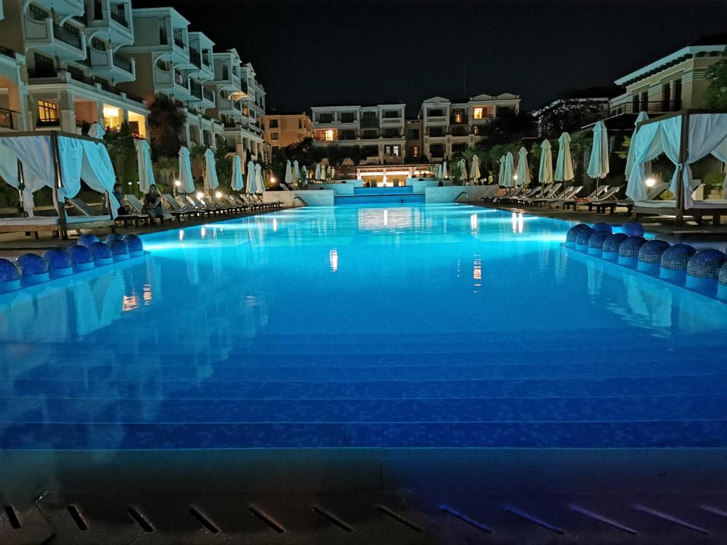 a large swimming pool with blue water at night at Green Life Apartments Sozopol in Sozopol