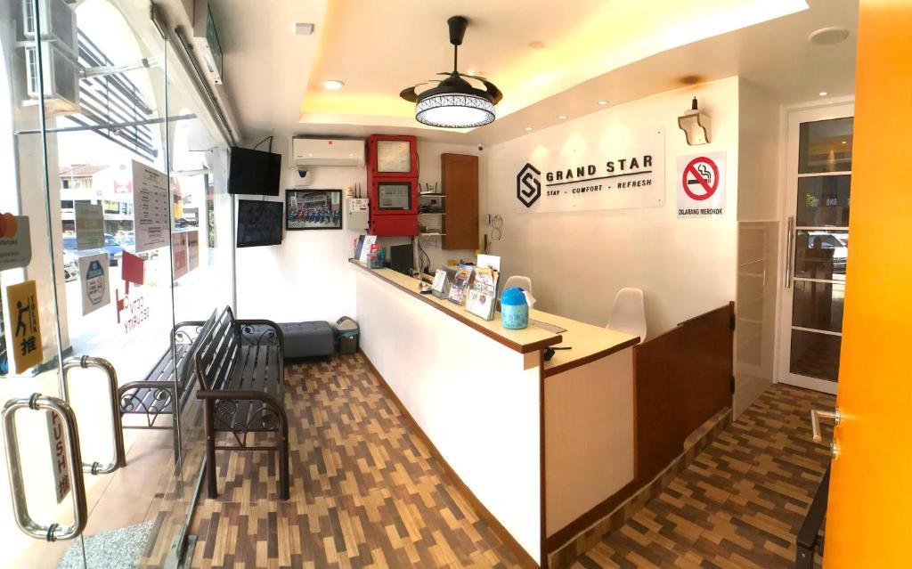 a small sushi restaurant with a counter and chairs at Grand Star Hotel in Malacca
