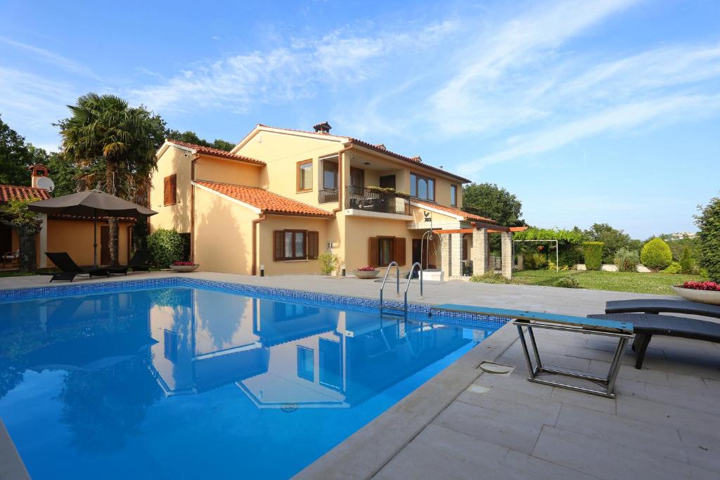 a villa with a swimming pool in front of a house at House Pauline in Labin