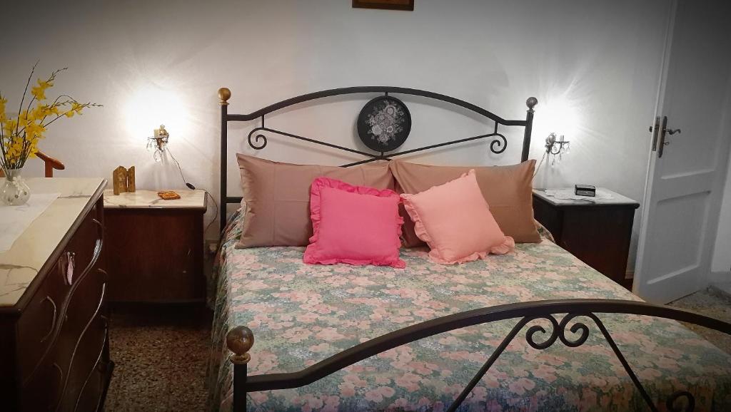 uma cama com almofadas cor-de-rosa e rosa em a casa di Gabri em Montefollonico