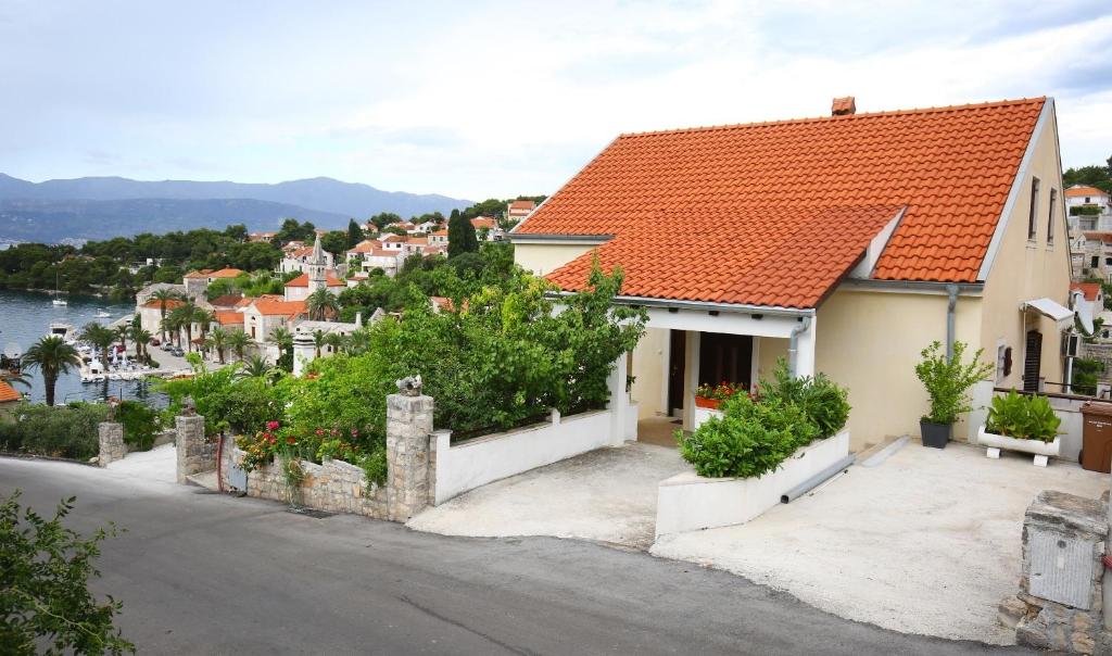 une maison blanche avec un toit orange dans l'établissement Apartments Neda - perfect location & free parking, à Splitska