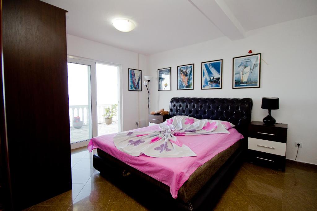 a bedroom with a large bed with a pink blanket at Apartments Dora in Dobra Voda