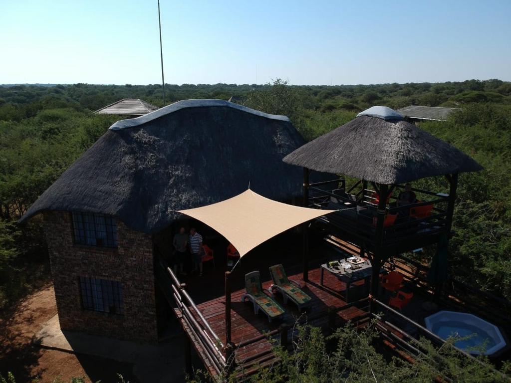 a building with umbrellas and tables and chairs at 515 on Warthog by the River in Marloth Park