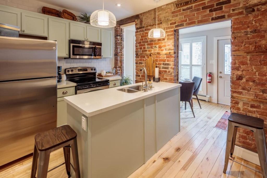 a kitchen with a brick wall and a counter top at The Hillside House - Downtown Kingston in Kingston