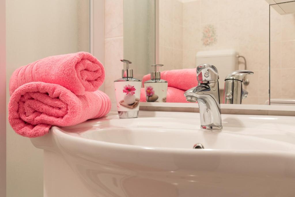 W łazience znajduje się umywalka i różowe ręczniki. w obiekcie Apartment Calista w Rabacu