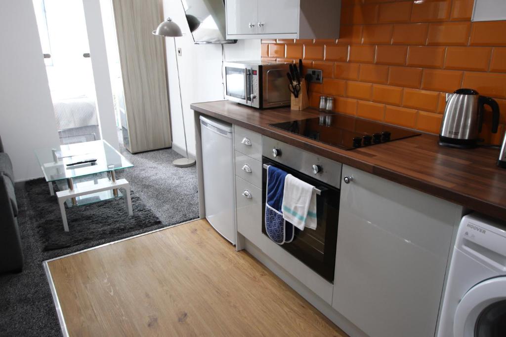 a kitchen with a stove and a microwave at Halifax House, Studio Apartment 207 in Halifax
