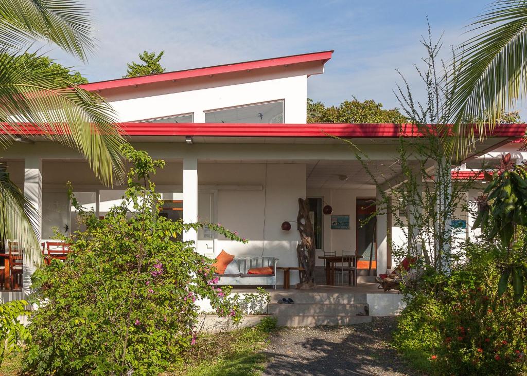 una pequeña casa blanca con techo rojo en Hotel Heliconia Panamá, en Malena