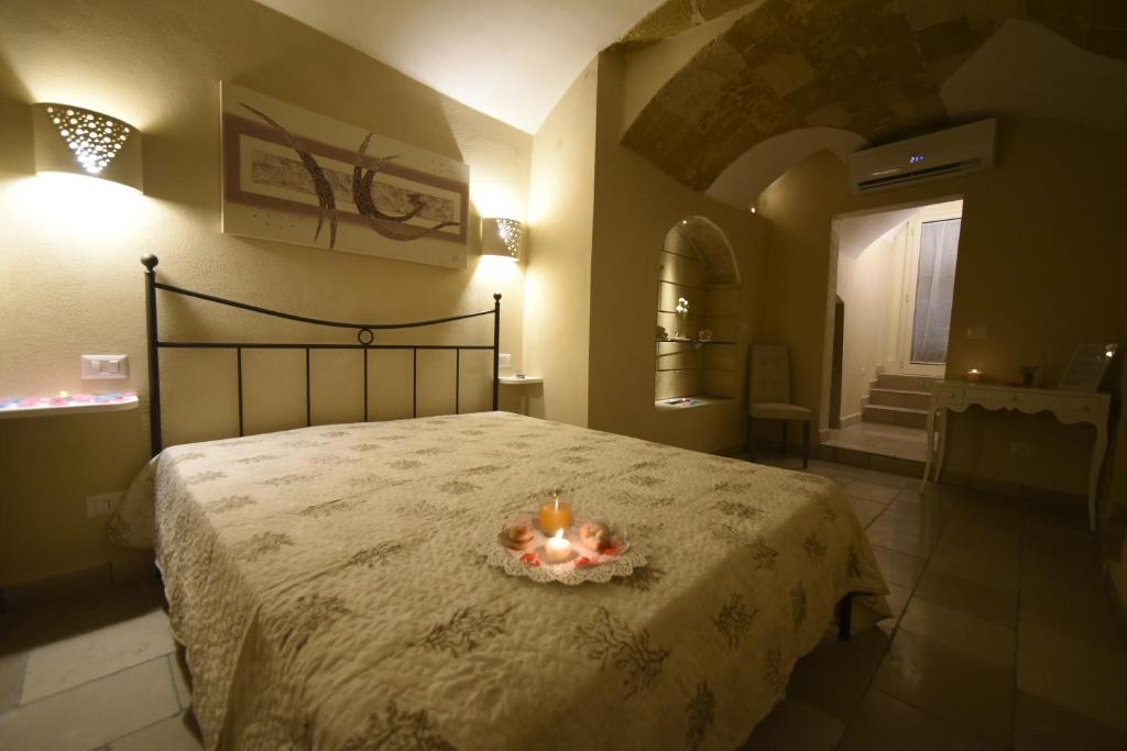 sypialnia z łóżkiem ze świecami w obiekcie B&B Corte Cantalupi w mieście Gallipoli