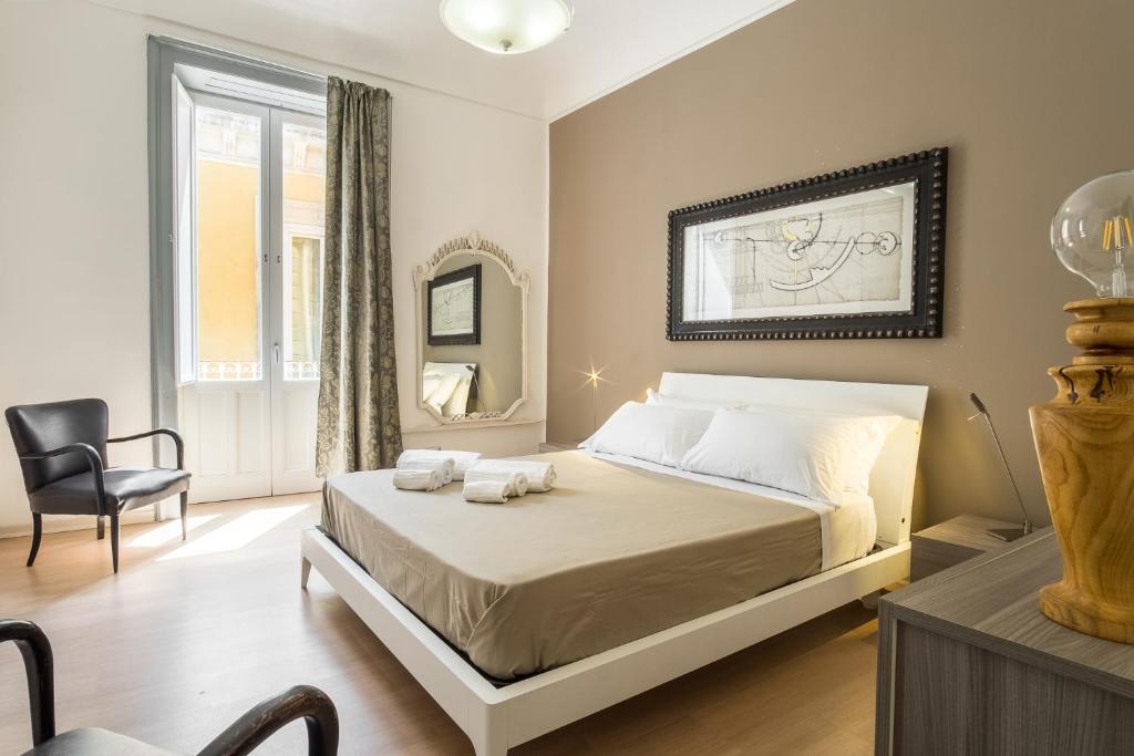 een slaapkamer met een bed en een stoel bij Art House in Siracusa