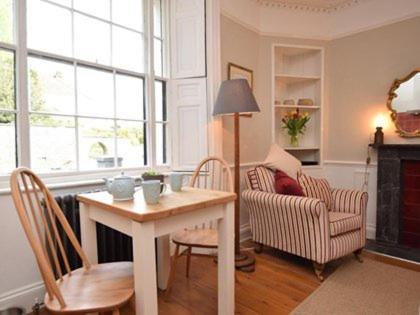 a living room with a table and chairs and a couch at Burton House Apartment in Lyme Regis