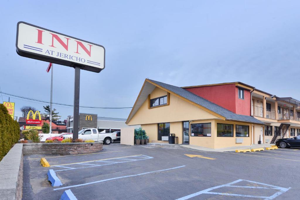 una señal para una posada en un estacionamiento en Inn At Jericho, en Jericho