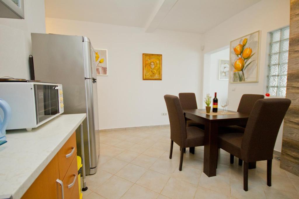 a kitchen with a table with chairs and a refrigerator at Apartments Dora in Dobra Voda