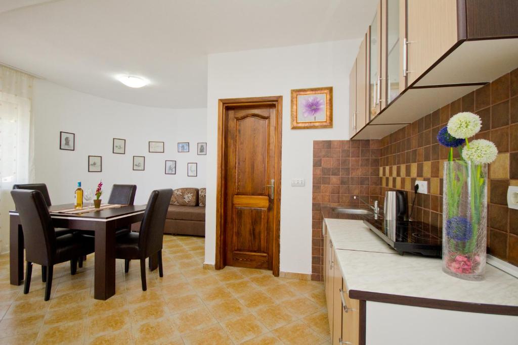 a kitchen and dining room with a table and chairs at Apartments Dora in Dobra Voda