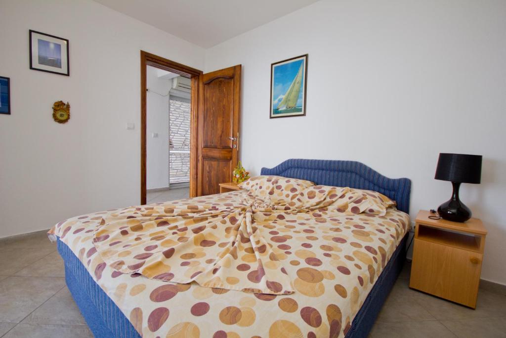 a bedroom with a bed and a table with a lamp at Apartments Dora in Dobra Voda