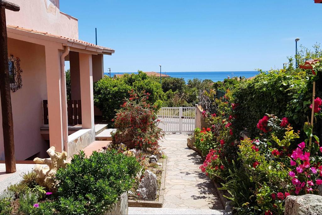a garden with flowers and the ocean in the background at La Meridiana IUN P2300 in Cala Gonone